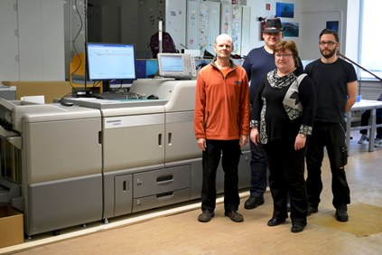 Drucker Wolfgang Hamann, Beschäftigter Wolf-Moritz Heinrich, Leiterin Kornelia Nimke und Drucker Philipp Borchers freuen sich über die neue Druckmaschine.